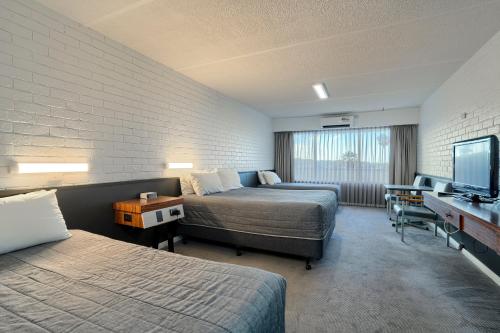 a hotel room with two beds and a flat screen tv at Dog Rock Motel in Albany