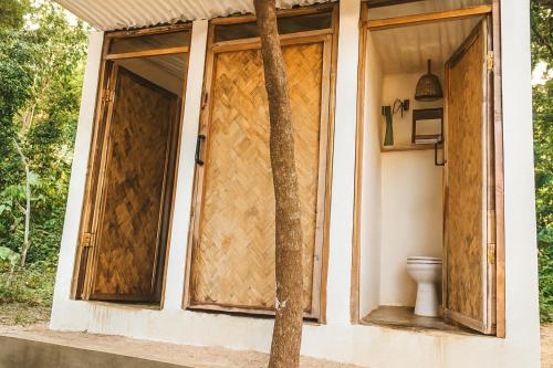 a toilet sitting outside of a house with a door at Kapsula El Nido in El Nido