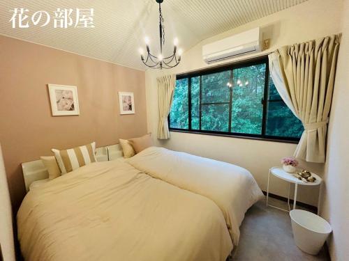a bedroom with a large bed and a window at HARMONIA 那須 Nas-MAX26名-川遊び-BBQ-カラオケのできる宿 in Nasu