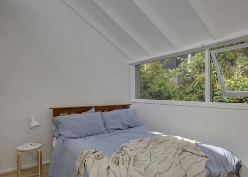 a white bedroom with a bed and two windows at Norah Beach Shack 2 in Norah