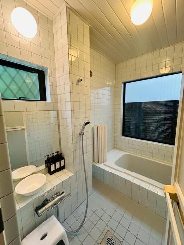 a bathroom with a tub and a sink at HARMONIA 那須 Nas-MAX26名-川遊び-BBQ-カラオケのできる宿 in Nasu