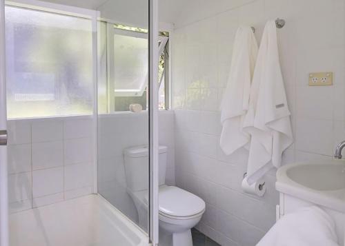 a white bathroom with a toilet and a shower at Norah Beach Shack 2 in Norah
