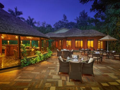 un restaurante con mesas y sillas por la noche en Taj Corbett Resort and Spa Uttarakhand en Rāmnagar