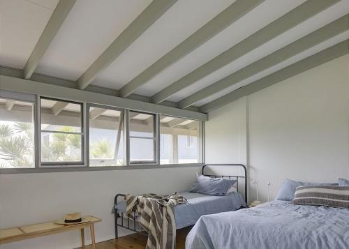 a bedroom with two beds and two windows at Norah Beach Shack 1 in Norah