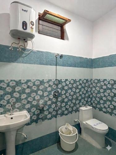 a bathroom with a sink and a toilet at Skyline Hotel in Uttarkāshi