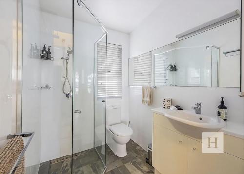 a bathroom with a toilet and a sink and a shower at Relaxing Getaway in Summerland Point