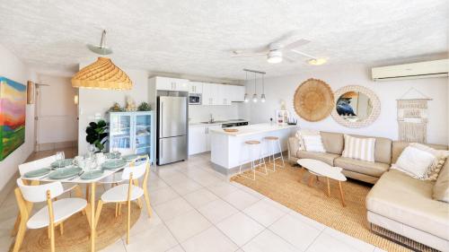 a kitchen and living room with a table and a couch at Merrima Court Holidays in Caloundra