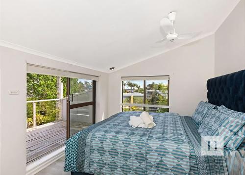 a bedroom with a bed with a stuffed animal on it at Paradise Palms in Mannering Park