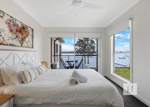 a bedroom with a bed and a view of the water at Sunset Central Coast in Mannering Park