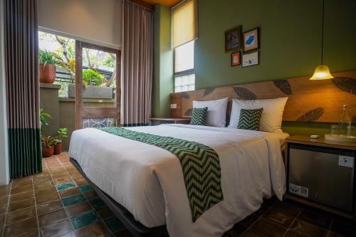 a bedroom with a large bed and a window at Songbird Boutique Inn in Canggu