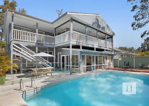 a large house with a swimming pool in front of it at The Place in Summerland Point