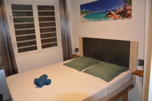a bedroom with a bed with a blue hat on it at L'évasion Maracuja in Gros-Morne