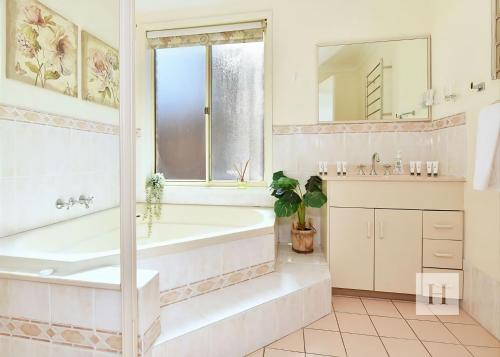 a white bathroom with a tub and a sink at Sparkling Waters in Rathmines