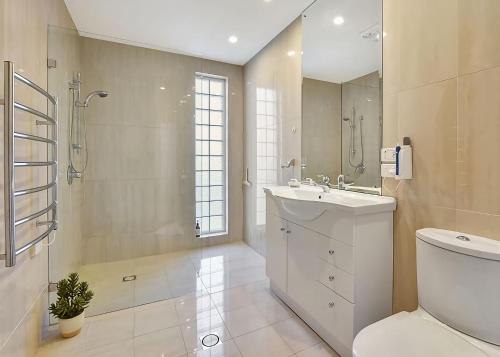 a bathroom with a toilet and a sink and a shower at The Sea Serenade in Blacksmiths