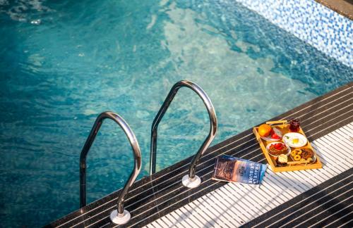 a tray of food sitting next to a swimming pool at Luxuria Varanasi By Moustache in Varanasi