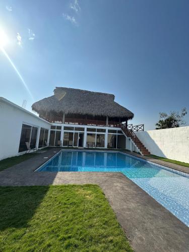een villa met een zwembad en een hut bij Villa Sal & Mar in Taxisco