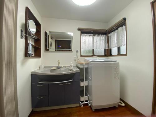 a bathroom with a sink and a mirror at お宿るり嘉鉄 in Setouchi