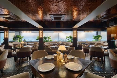 a restaurant with tables and chairs and windows at Hotel Silver Inn Near Mumbai Airport in Mumbai