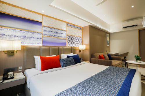 a bedroom with a large bed and a living room at Hotel Silver Inn Near Mumbai Airport in Mumbai
