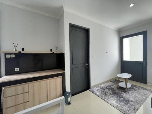 a room with a door and a table and a stool at Sanur House Lavender in Sanur
