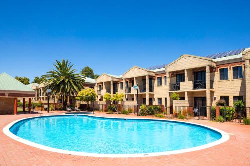 a swimming pool in front of some apartments at Country Comfort Perth in Perth