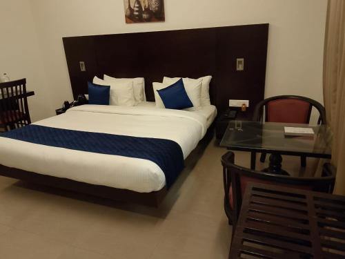 a bedroom with a large bed and a table at Hotel Gentleman Mithila in Eramalloor