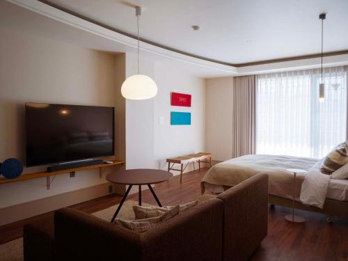 a bedroom with a bed and a tv and a couch at Hotel Espacio 山口 -ADULT ONLY- in Yamaguchi