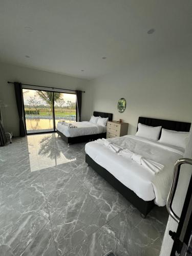 a large bedroom with two beds and a large window at The Forest Pool villa & cafe in Ban Wang Yao
