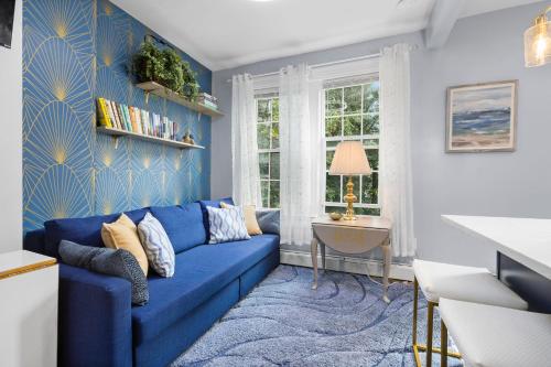 a blue living room with a blue couch and a table at Bright 2BR Retreat Walk to PATH NYC Access in Jersey City