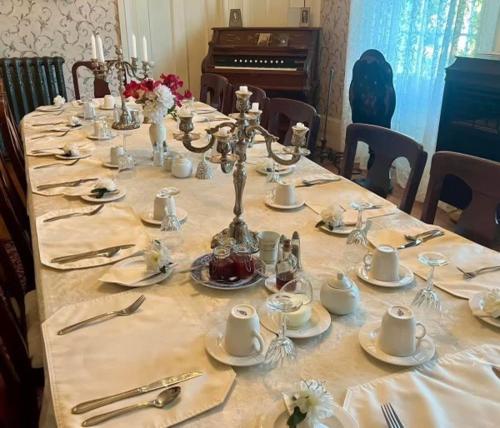 a long table with plates and utensils on it at Manoir Hamilton in New Carlisle