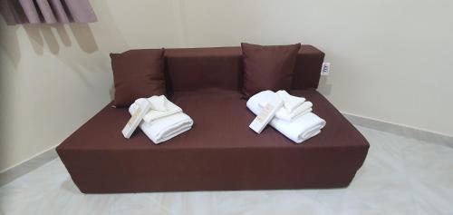 two pairs of white shoes sitting on a brown couch at Secret Garden Inn in Tagum