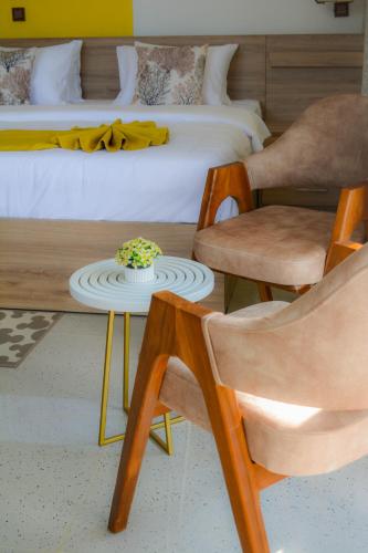 a bedroom with a bed and a table and chairs at 3Arch Eco Cottage Ella in Ella