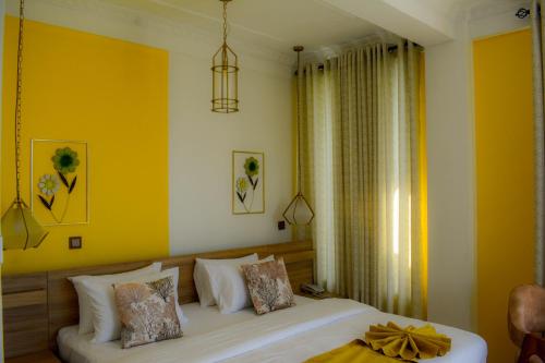 a bedroom with a bed and a yellow wall at 3Arch Eco Cottage Ella in Ella