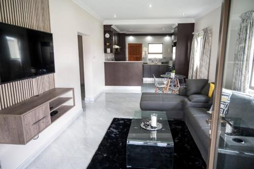 a living room with a couch and a table at Little leisures in Matsapha