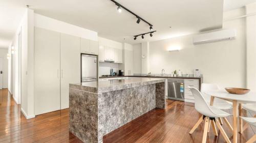 a kitchen with a counter with chairs and a table at New York Style Apartment in Bendigo