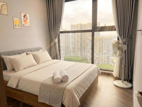 a bedroom with a bed and a large window at Oliver's vacation home - Vinhomes Grand Park in Long Bình