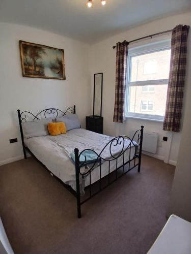 a bedroom with a bed and a window in it at Victoria Guest Apartment in Ramsgate
