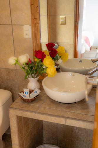 a bathroom with a sink and flowers on a counter at Seven Machupicchu in Machu Picchu