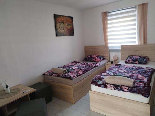 two twin beds in a room with a window at Margit Haus in Stara Moravica