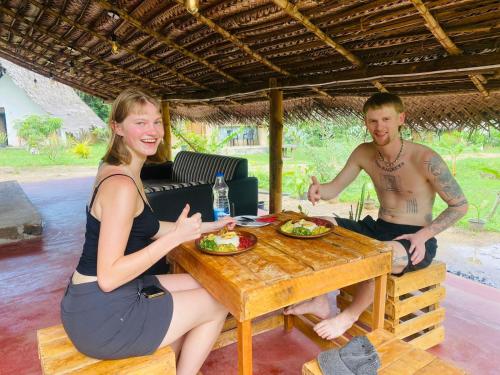 a man and a woman sitting at a table with food at The Forest Edge Resort in Dambulla