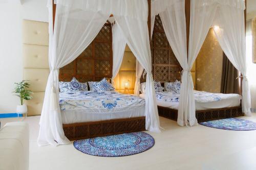 two beds in a bedroom with curtains and rugs at Private Pool Party Villa games Karaoke, in Nonthaburi