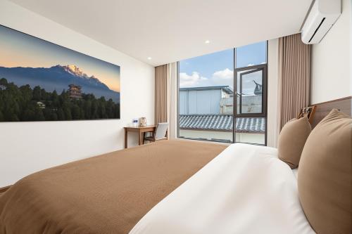 a bedroom with a large bed and a large window at 熹楠丽江古城 in Lijiang