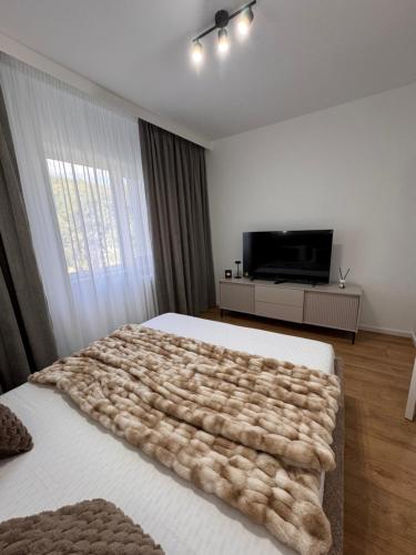 a bedroom with a bed with a furry blanket on it at Olt view apartament in Călimăneşti