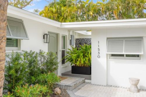 a white house with a porch with plants at Wait N' Sea- Previously Millertime home in Captiva