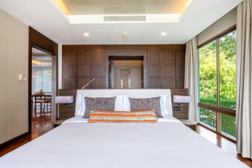 a bedroom with a large white bed and large windows at CasaVela 213 - 2BR apartment Seaview in Natien Beach