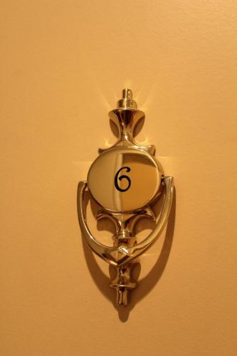 a gold clock on a wall with the number six at Le Mas Du Colombier in Cadenet