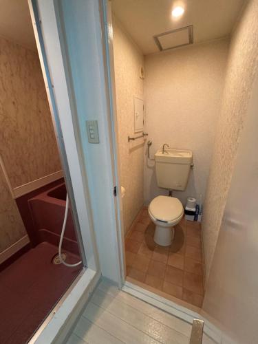 a small bathroom with a toilet and a shower at KIYAZA Road Sapporo in Sapporo