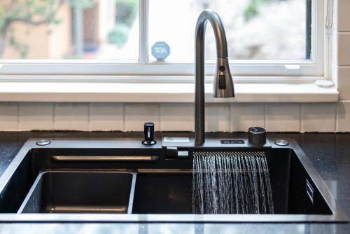 a kitchen sink with a stream of water at Villa in the Valley in Pokolbin