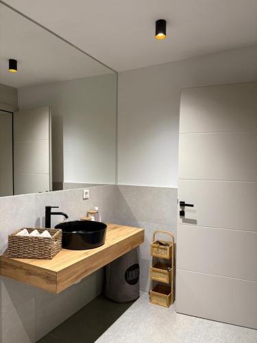 a bathroom with a sink and a mirror at Apartment Delux in Posušje