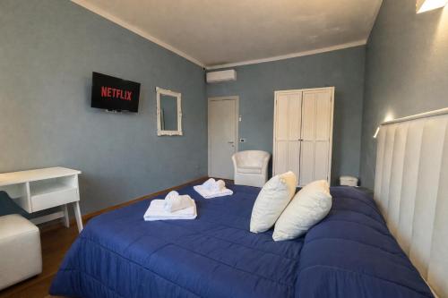 a bedroom with a blue bed with two towels on it at "La Sala di Dante" Wi-Fi, Smart Tv, AC, Bagno Privato in Pistoia